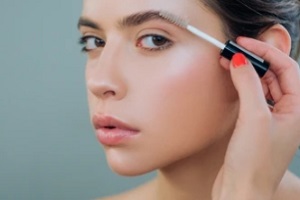 women brushing eyebrows with private label brow products